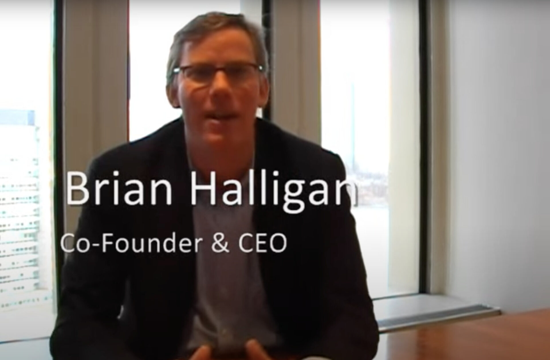 A man, identified as brian halligan, seated and speaking in an office setting, with text overlay stating his name and title as co-founder & ceo.