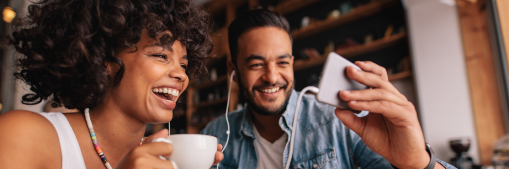 Two people smiling and enjoying coffee together at a cafe, captured in a Biteable video.