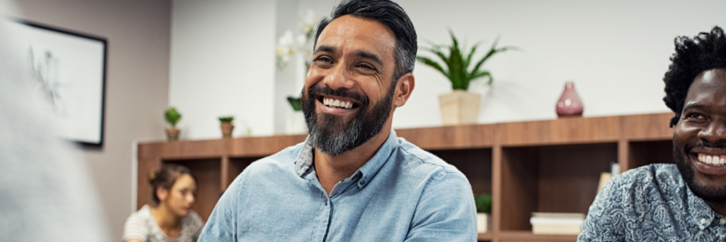 Two men smiling in a bright office environment.