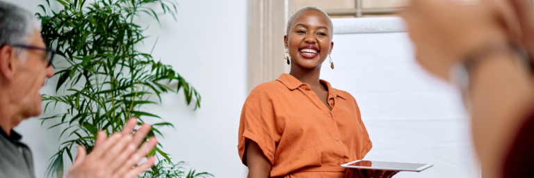 A smiling woman engaging in a conversation in a bright office environment, highlighted in a Biteable video maker presentation.