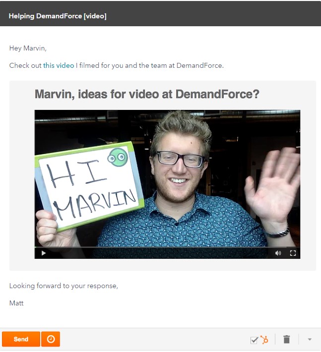 A man holding a sign with "hi marvin" written on it, waving at the camera.