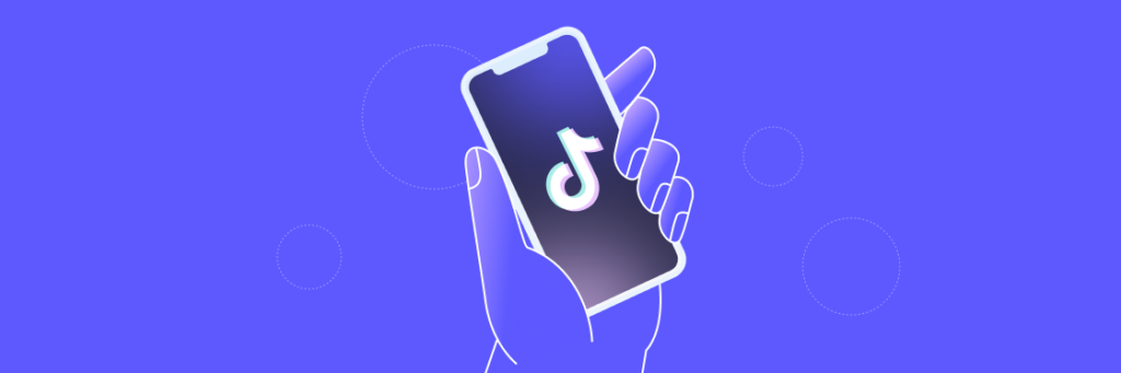 A hand holding a smartphone displaying the Biteable video maker logo on its screen, with a purple background and abstract white circles.