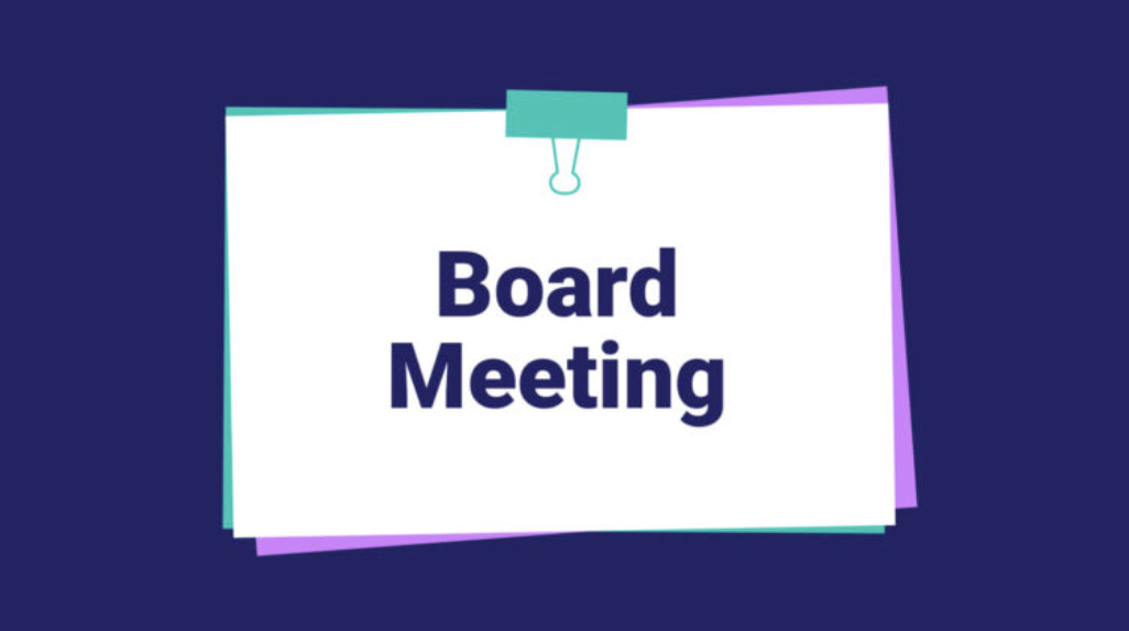 A sign indicating a 'board meeting' is in session or upcoming, attached to a wall or board with a paper clip.