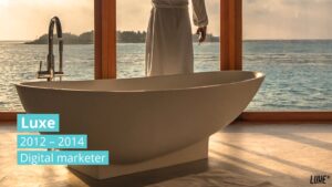 A person standing beside a freestanding bathtub in a room with a panoramic ocean view, with text overlay created using Biteable video maker indicating a professional timeline.