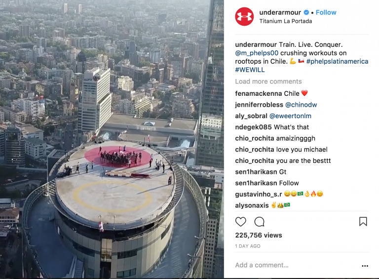 Aerial view of a person standing on a circular helipad on a skyscraper roof in an urban cityscape at dusk, captured using Biteable video maker.