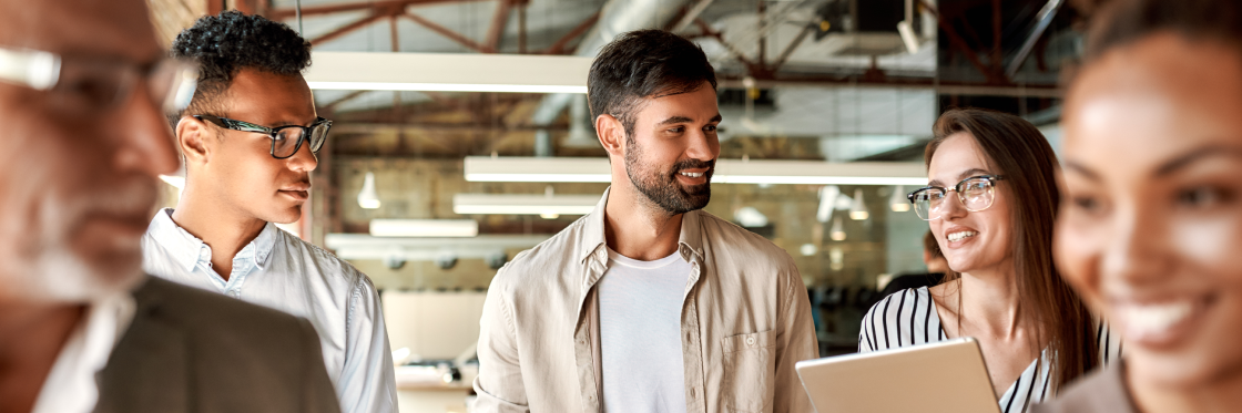 7 Ways to Improve Your Internal Communications A diverse group of professionals engaging in a discussion while walking through a modern office space.